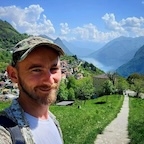 a man in a hat smiles at the camera. 