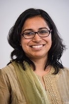 a woman in a green shirt smiles at the camera. 