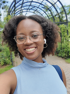 A woman in a blue shirt smiles at the camera. 
