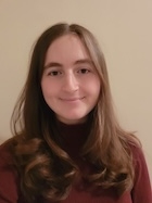 A woman in a red shirt smiles at the camera. 
