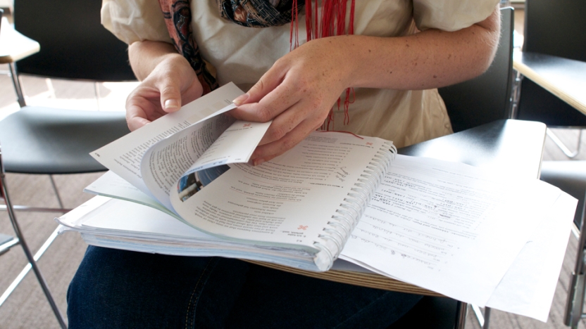 German language student flipping through textbook.