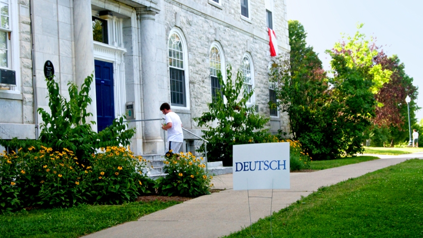 Male student walking into marble building on Middlebury campus.