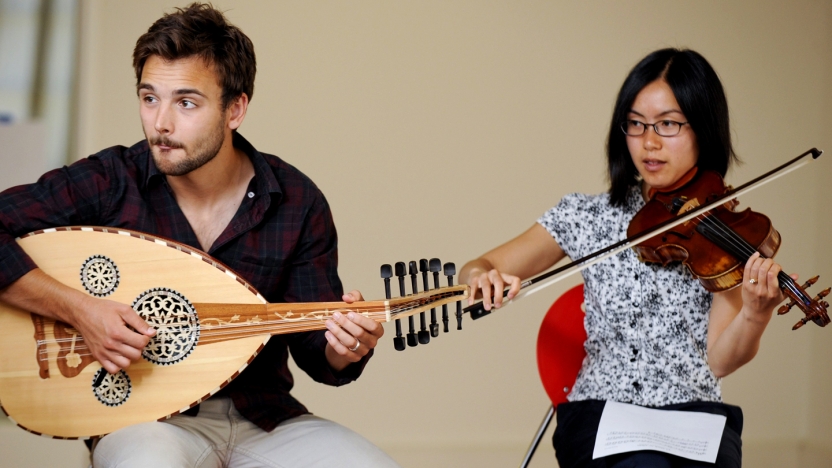 Two Arabic students playing instruments.