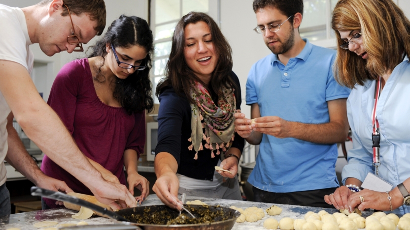 Five Arabic students cooking together.