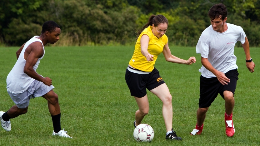 Three Portuguese school students playing soccer.