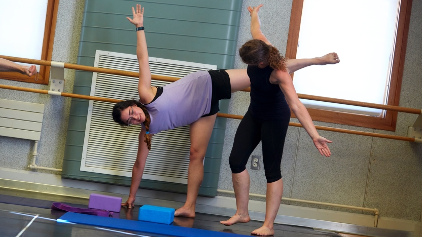 Two female School of Hebrew students practicing yoga.