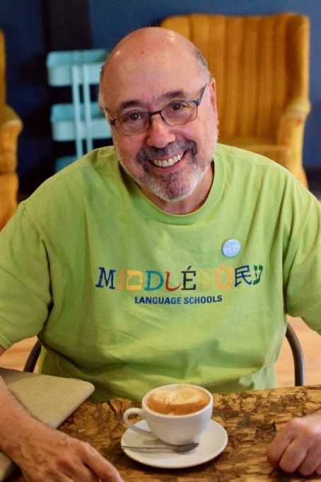 Hebrew Lifelong Learner drinking a cup of coffee, smiling at camera.