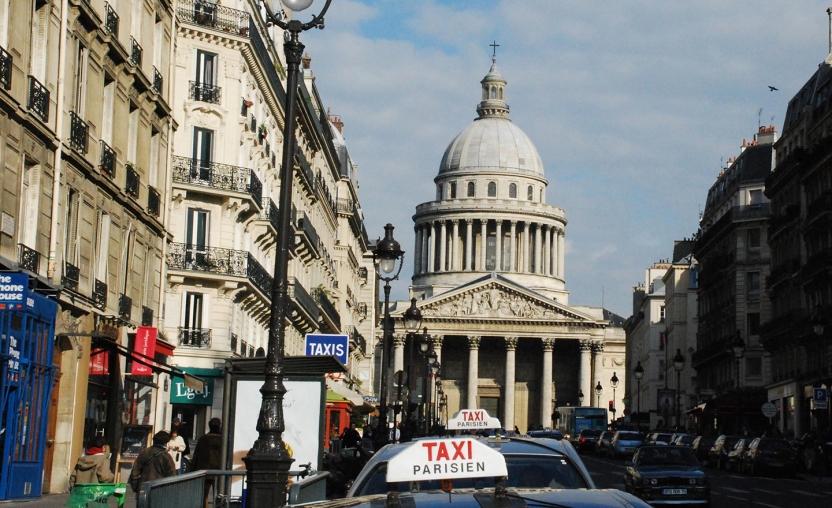 Paris street with domed building at the end.