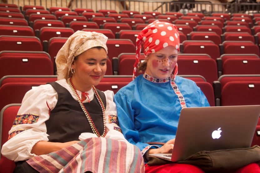 Two girls dresssed up work on their computer.