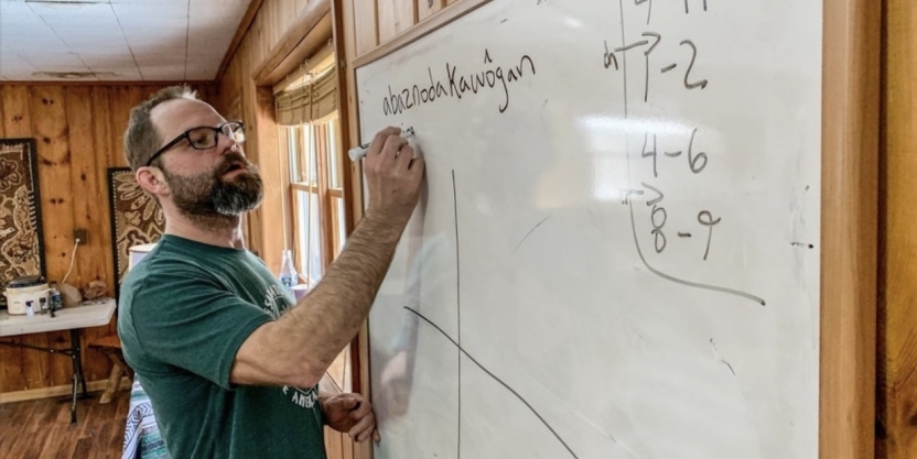 Director of the Abenaki program writes on a white board.