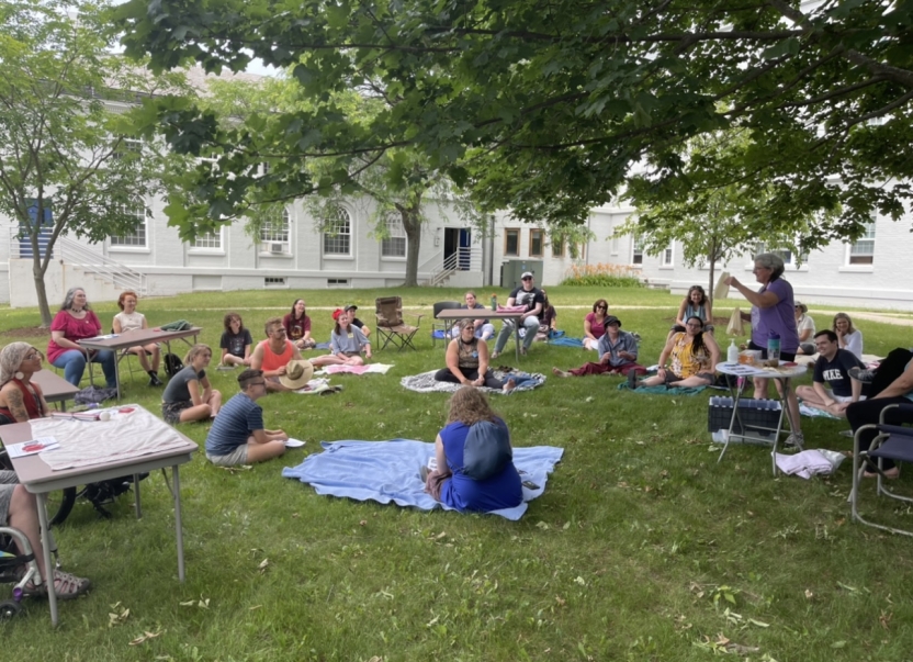 The Abenaki students sit outside.