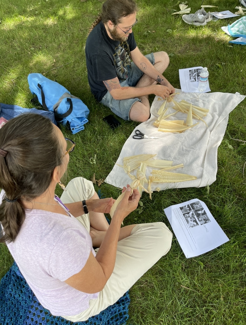 Students do arts and crafts outside with Abenaki culture.