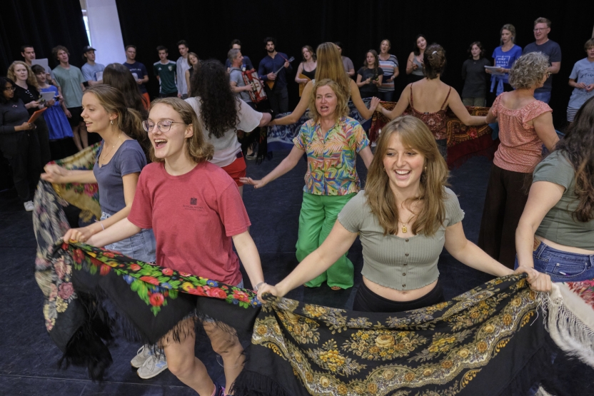 Students at the Russian school dance with colorful scarves in a circle.