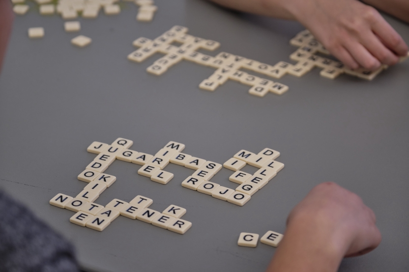 Scrabble tiles spell out words in Spanish: sugar, nota, toner etc. 