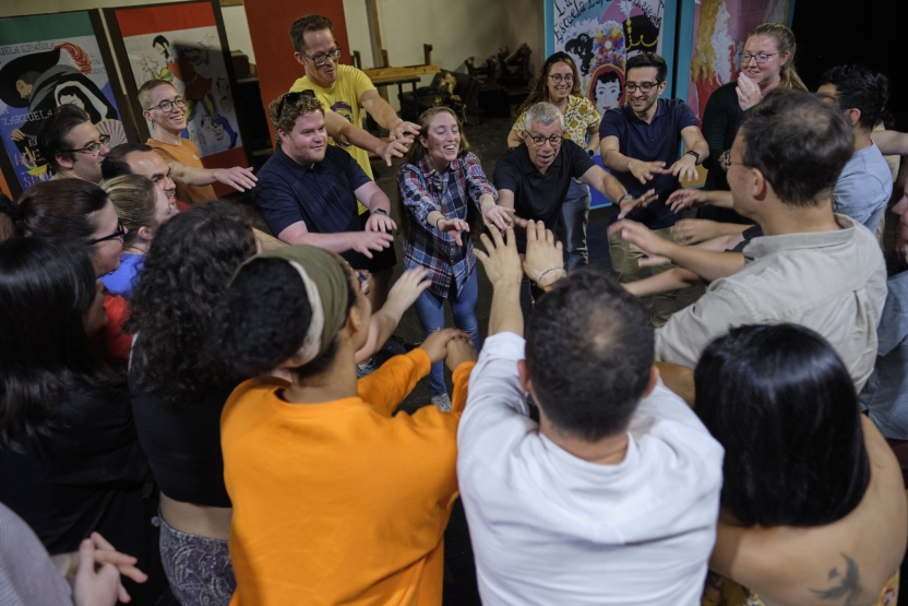 A group of people joins their hands together for a cheer. 