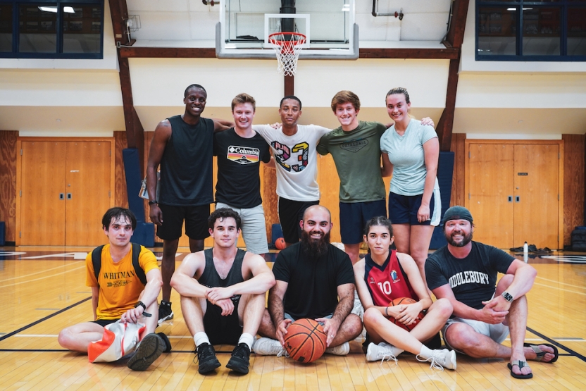 Students stand shoulder to shoulder as a team after a basketball game.