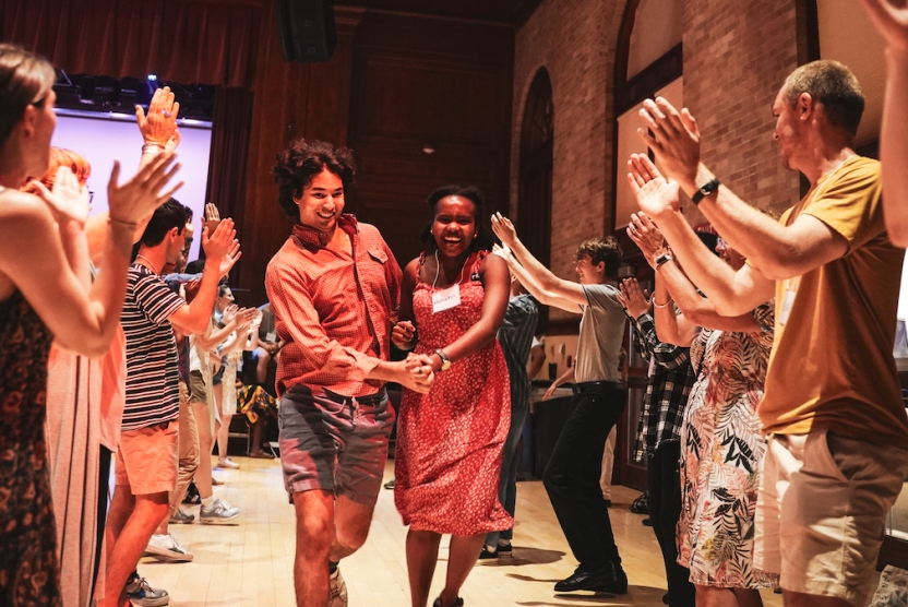 Students dance through a line made up of spectators together. 