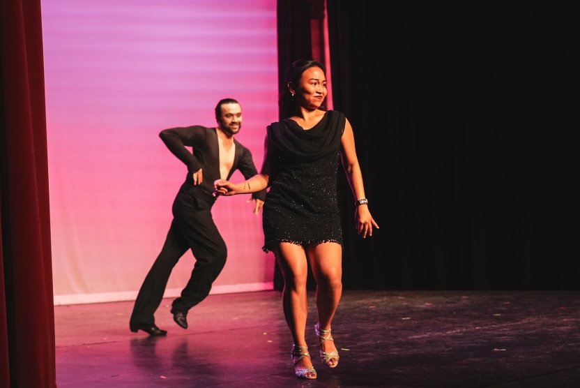 A woman and man perform a dance together on stage. 
