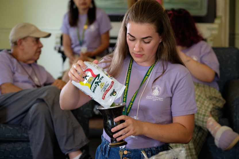 A student pours mate into her cup. 