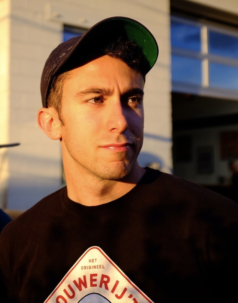 A man in a black baseball cap looks off to the side.