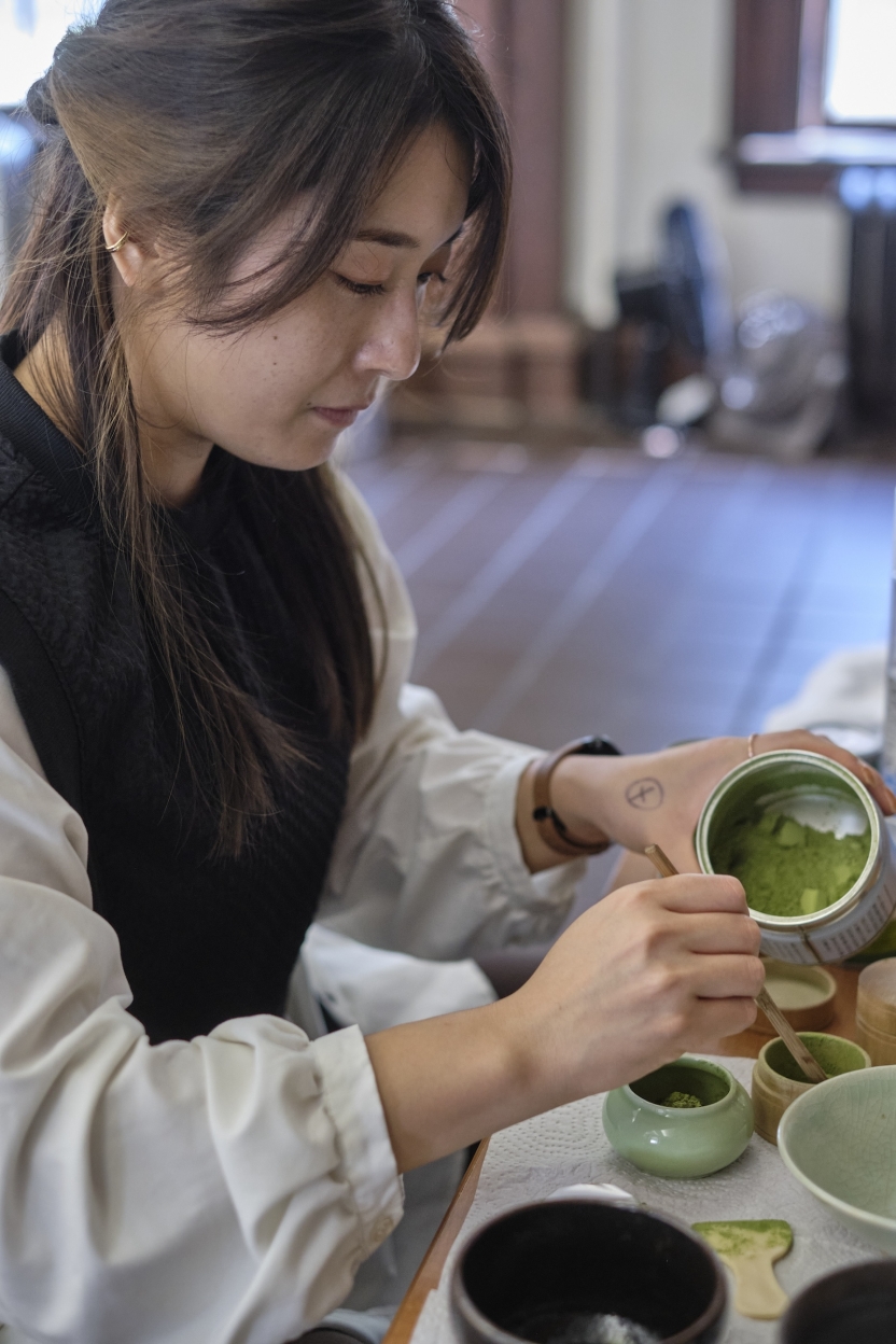 A student at the School of Japanese scoops tea.