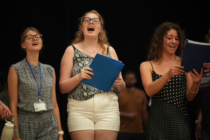 Staff and students sing in a choir. 