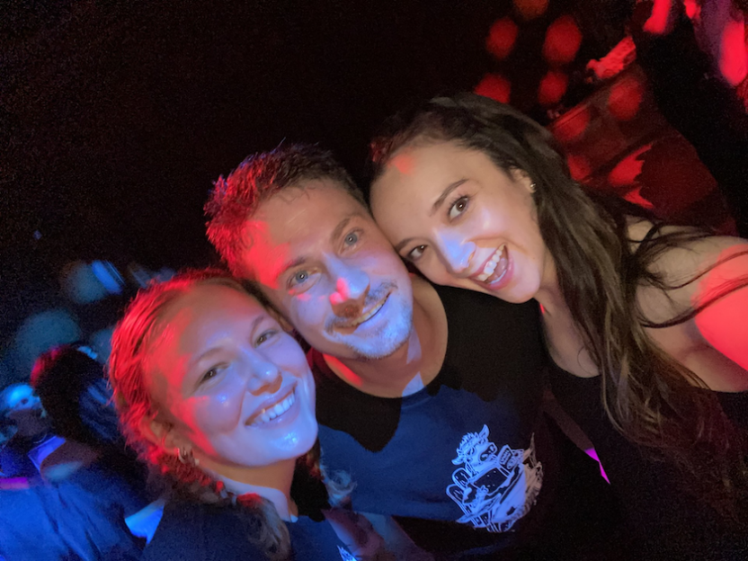 A man and two women at a dance party.