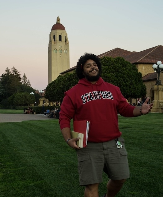 A student in a red sweatshirt smiles at the camera.