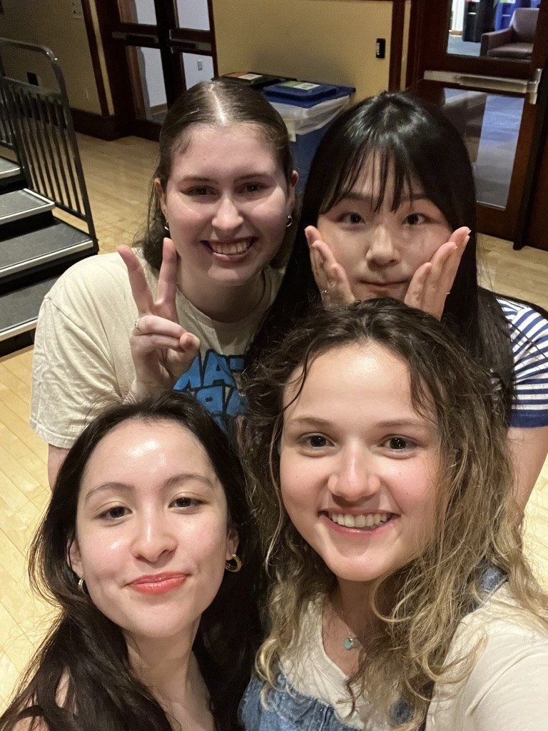 Students pose for a picture, signing with their hands in different ways. 