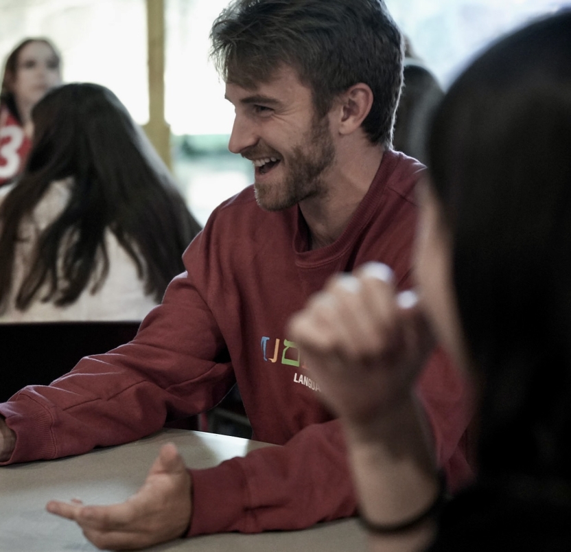 A smiling man in a red sweatshirt