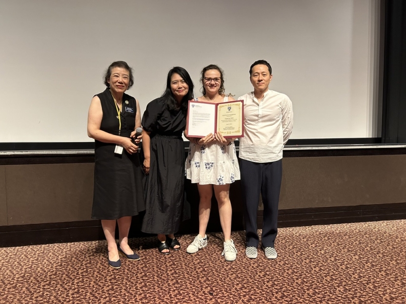 A student poses with a certificate with her mentors. 