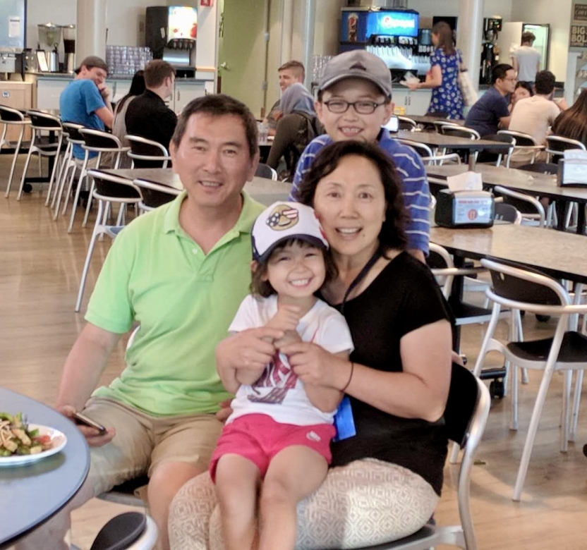A father and mother with their children in a dining hall. 