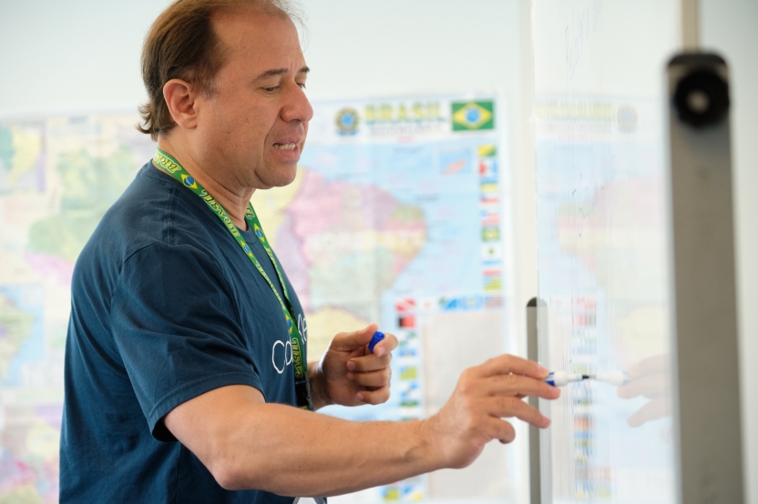 A teacher writes on the whiteboard in class.