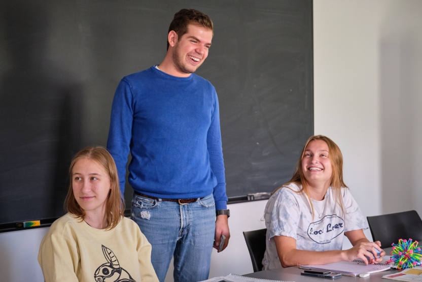 A faculty/staff member smiles with his students. 
