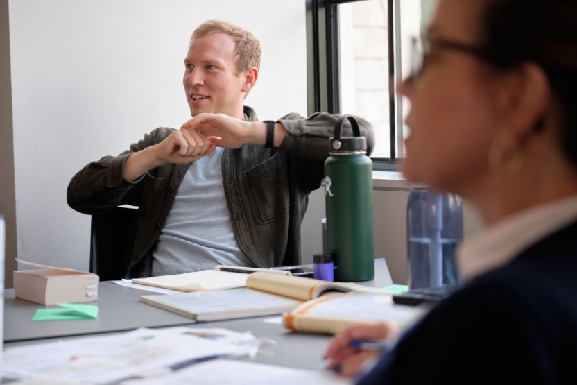 A man smiles while he listens in class. 