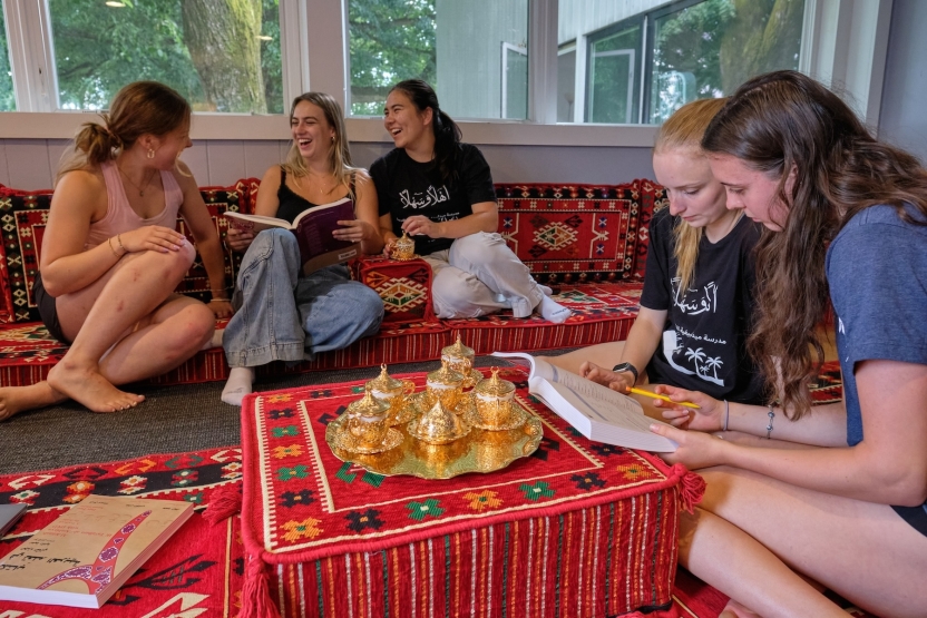 Students smile and study with their tea. 