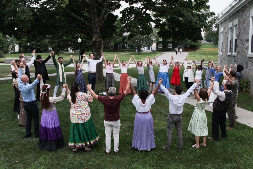 A group of students hold hands in a circle. 