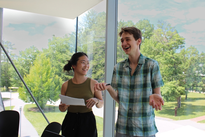 Students present in class in front of a picture window. 
