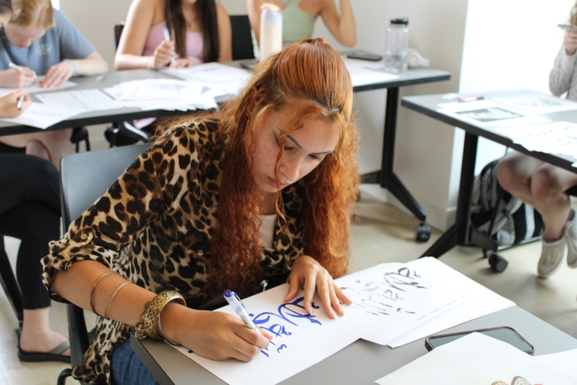 A student works on her Arabic calligraphy. 