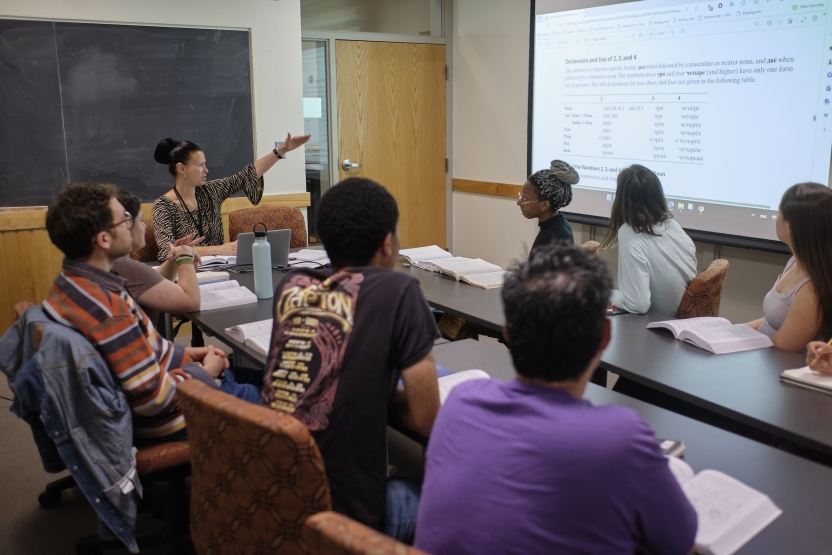 Students look at a screen with their teacher in class. 