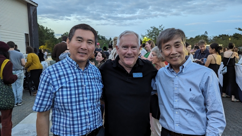 A group of men smile for a picture. 
