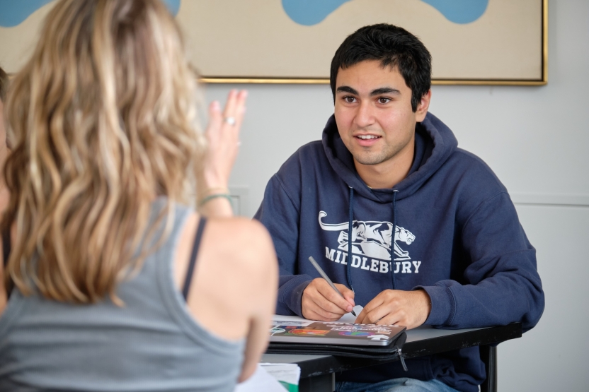 A student in a Middlebury sweatshirt talks to a classmate. 