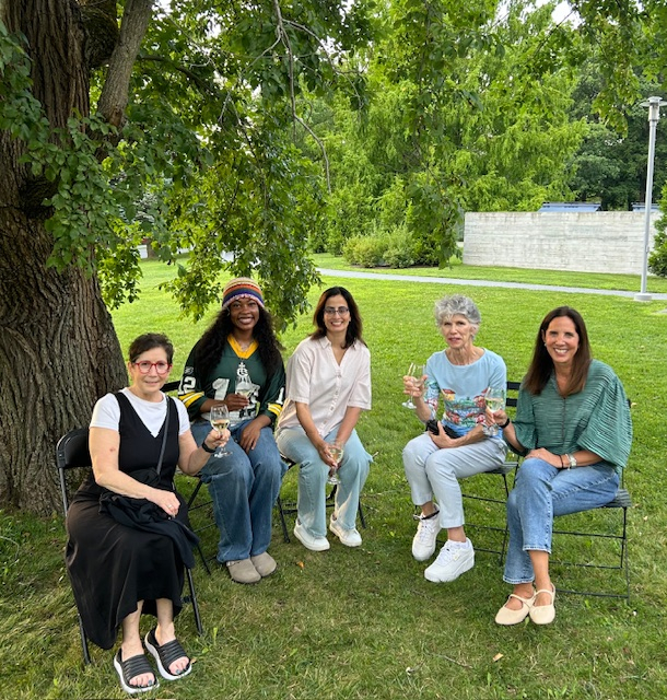 A group of Italian School students with wine glasses in a circle outside. 