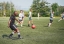 A group of men play soccer outside on a grass field.
