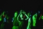 Students dance in green light with headphones on, a silent rave.