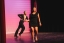 A woman and man perform a dance together on stage.