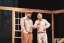 Two men, actors in a play look at each other smiling.