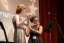 Two students play the flute together on stage. 