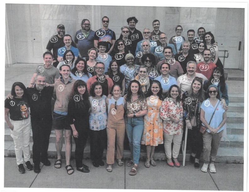 Staff stand on the steps together, smiling.