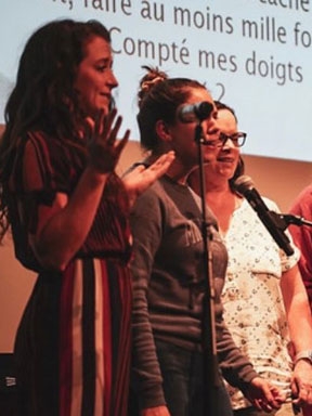 Students performing a song in French during an open mic night.